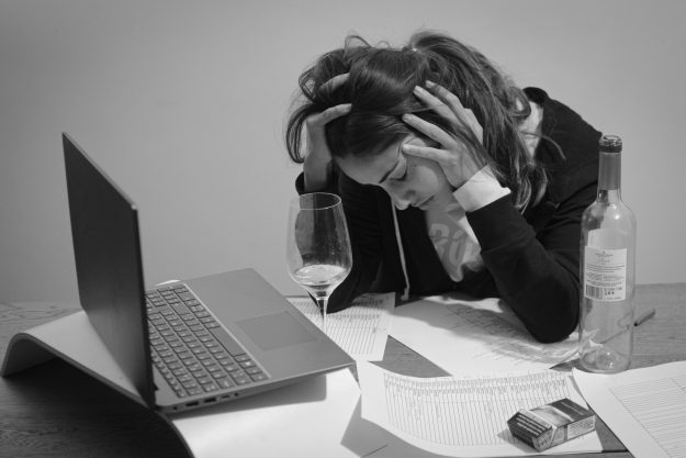 Persona-con-le-mani-sul-viso-appoggiata-ad-una-scrivania2 Social Media E Depressione Giovanile